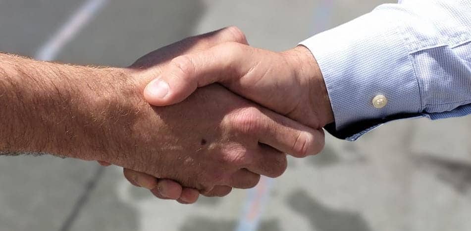 Handschlag zwischen zwei Unternehmern – Symbol für vertrauensvollen Betriebsrechtsschutz und rechtliche Sicherheit für KMU in Salzburg